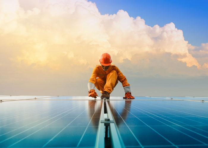 uomo su tetto con pannelli solari